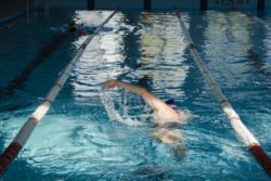 W basenie sportowym - widok płynącego chłopaka kraulem