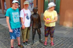 Dwóch chłopców i dziewczynak przy figurze Ludwika Zamenchofa.