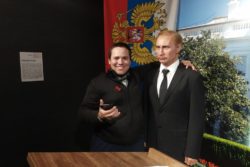 Mężczyzna stojący obok woskowej figury Władymira Putina.