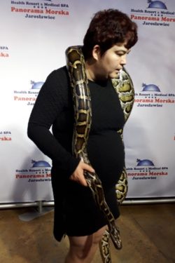 Kobieta trzymająca na ramionach węża.
