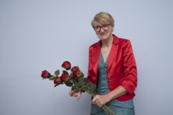 Kobieta z bukietem czerwonych róż.