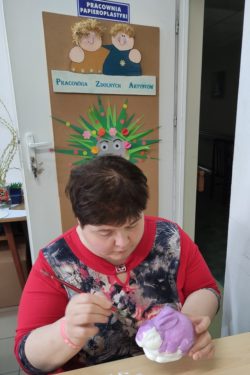 Kobieta malująca styropianowego królika.