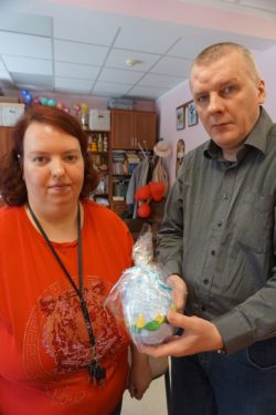 Kobieta i mężczyzna prezentują zapakowane jajo wielkanocne.