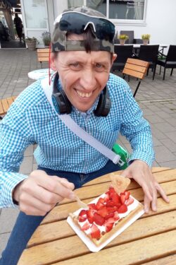 Mężczyzna jedzący gofra z owocami.