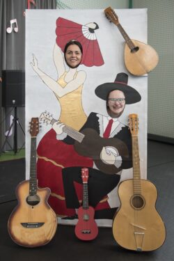 Dwie kobiety na planszy przedstawiającej kobietę i mężczynę z gitarą.