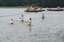 Osoby kąpiące się w jeziorze.