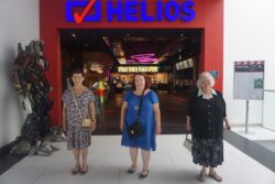 Trzy kobiety stojące przed wejściem do kina.