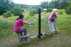 Dwie kobiety ćwiczące na podwórkowej siłowni.