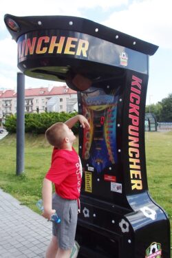 Chłopiec stojący przy automacie z piłką.