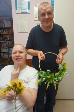 Dwaj mężczyźni trzymający bukiety kwiatów.