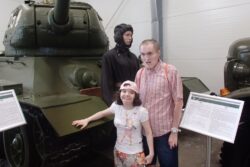Dziewczynka i chłopiec stojący przy czołgu.