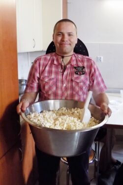 Mężczyzna trzymający w rękach dużą miskę z popcornem.