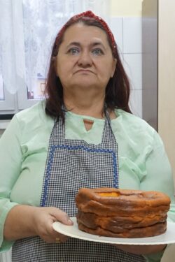 Kobieta trzymająca w rękach talerz z ciastem.