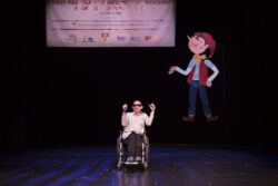 Mężczyzna na wózku inwalidzkim na scenie.