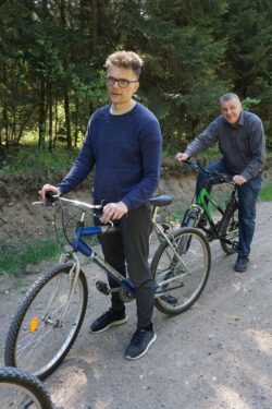 Dwaj mężczyźni stojący przy rowerach.