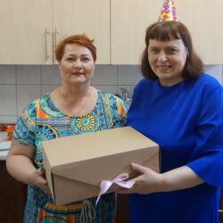 Dwie kobiety trzymające wspólnie kartonowe pudło.