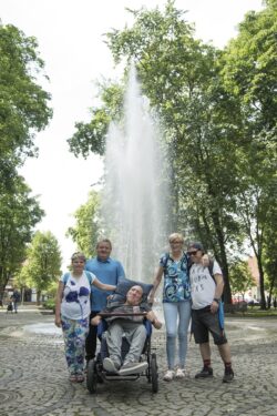 Zdjęcie grupowe. Pięć osób stojąca na placu przed fontanną.