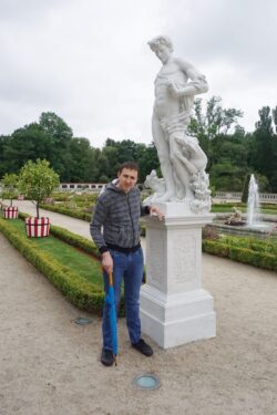 Mężczyzna stojący przy rzeźbie w parku.