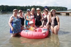 Grupa kobiet w strojach kąpielowych stojąca w wodzie w jeziorze.