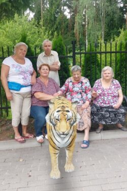 Mężczyzna i trzy kobiety przed którymi stoi tygrys.