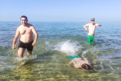 Trzej chłopcy kąpiący się w morzu.
