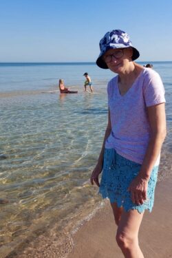 Kobieta stojąca nad brzegiem morza.
