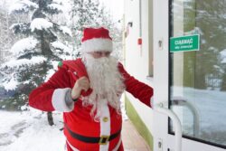 Mikołaj otwierający drzwi do budynku.